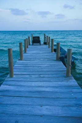 a wooden pier with a bench on the water at Villa Luz Coastal Sanctuary in Tintipan Island