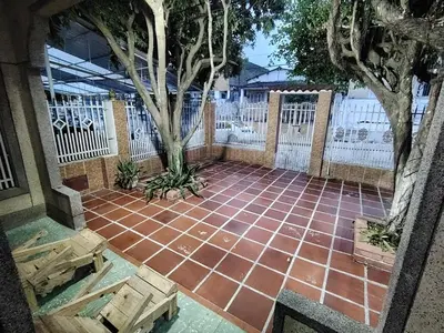 a brick patio with a tree and a fence at Casa yamulemao in Cartagena de Indias