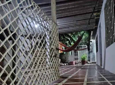 a stone wall in a building with a red hose at Casa yamulemao in Cartagena de Indias
