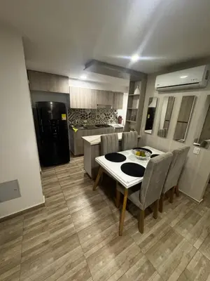 a kitchen with a table and chairs and a refrigerator at New & peaceful apartment in Barranquilla