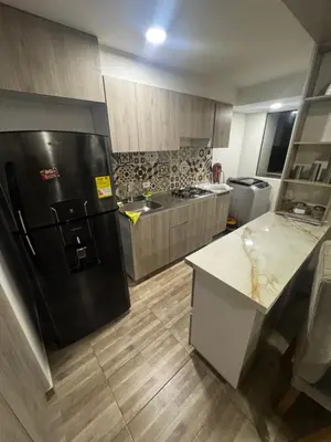 a kitchen with a black refrigerator and a sink at New & peaceful apartment in Barranquilla