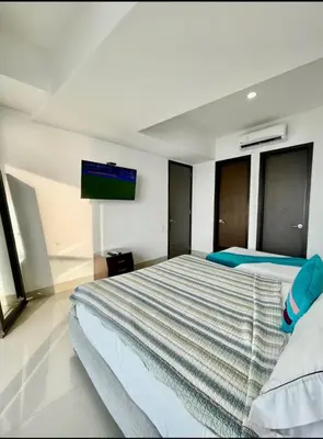 a bedroom with a bed and a tv on the wall at 1PE-AL Apartamento de 1 alcoba frente al mar con Aire acondicionado, Piscina y Wifi in Cartagena de Indias