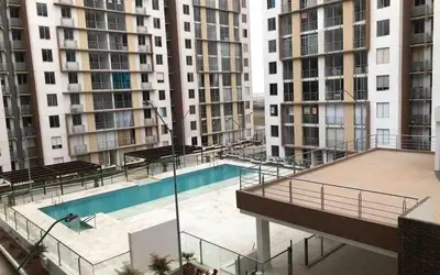 a swimming pool in the middle of two tall buildings at Modern and cozy apartment at north in Barranquilla