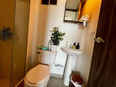 a bathroom with a toilet and a sink and a plant at Modern and cozy apartment at north in Barranquilla