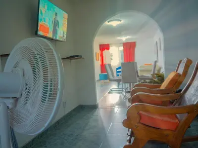 a room with a large white fan and chairs at Lovely and close to airport, sea, and old town in Cartagena de Indias