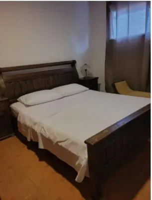 a bedroom with a large bed with a wooden headboard at Hospedaje Refugio del Caribe in Cartagena de Indias