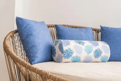 a wicker chair with blue cushions and a pillow at Suite Familiar Vista al Mar, Day Bed WiFi CB1315 in Cartagena de Indias