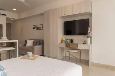 a room with a bed and a couch and a television at Suite Familiar Vista al Mar, Day Bed WiFi CB1315 in Cartagena de Indias
