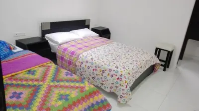 a bedroom with two beds with a colorful blanket at Hotel Mar di Plata in Barranquilla