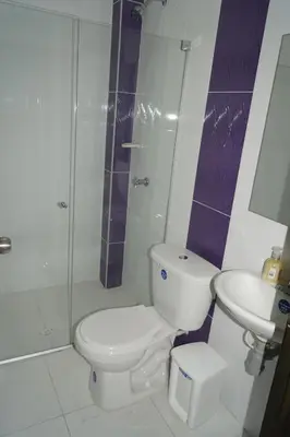 a bathroom with a toilet and a shower and a sink at Hotel Mar di Plata in Barranquilla