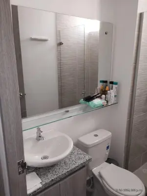a bathroom with a sink and a toilet and a mirror at Apto Nuevo Mallorquín Barranquilla in Barranquilla