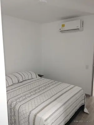 a bed in a room with a white wall at Apto Nuevo Mallorquín Barranquilla in Barranquilla
