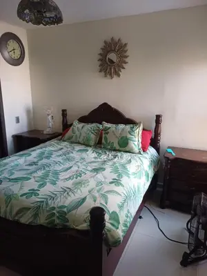 a bedroom with a bed and a clock on the wall at Oporto in Barranquilla