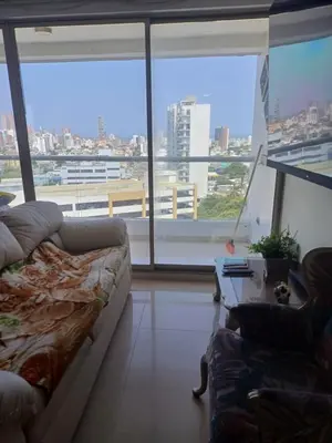 a living room with a couch and a large window at Oporto in Barranquilla