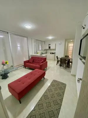 a living room with two red couches and a kitchen at Apartamento nuevo a 300 mts malecón del rio in Barranquilla