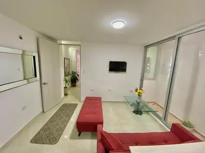 a living room with a red couch and a glass table at Apartamento nuevo a 300 mts malecón del rio in Barranquilla