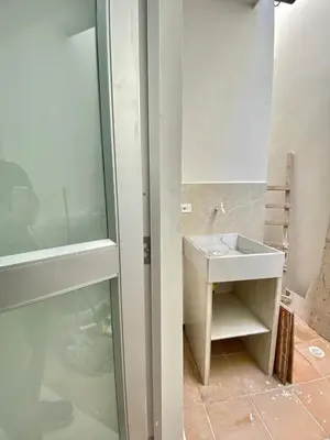 a bathroom with a sink next to a glass door at Apartamento nuevo a 300 mts malecón del rio in Barranquilla