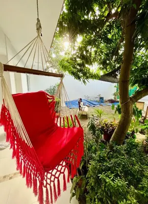 a red hammock hanging from a tree at Refugio playero - A pasos del Mar in La Siriaca