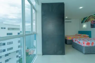 a bedroom with two beds and a large window at Aparamento Vista Mar 1703 in Cartagena de Indias