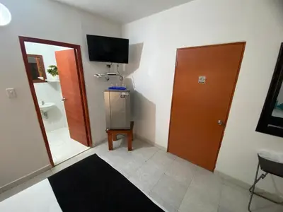 a room with a mirror and a door and a television at Paraíso en Bocagrande habitaciones in Cartagena de Indias