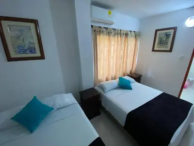 a bedroom with two beds and a window at Paraíso en Bocagrande habitaciones in Cartagena de Indias