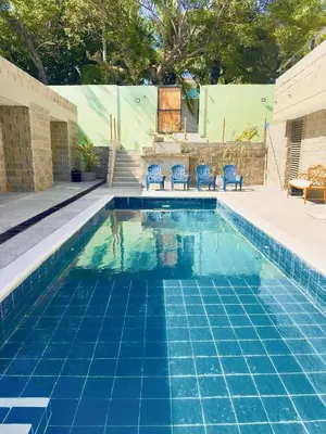 a swimming pool with blue chairs and a blue tile pool at Villa pio blue in Santa Veronica