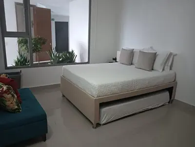 a bedroom with a bed and a couch and a window at Altamar vista al mar in Cartagena de Indias