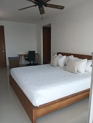 a bedroom with a large bed with a ceiling fan at Altamar vista al mar in Cartagena de Indias