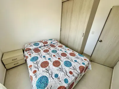 a small bedroom with a bed with a floral bedspread at Julius Sky Apartment 1-Swimming pool and close to the beach in Cartagena de Indias