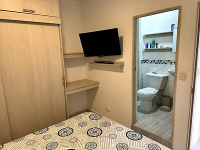 a small bathroom with a toilet and a television at Julius Sky Apartment 1-Swimming pool and close to the beach in Cartagena de Indias