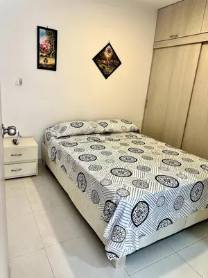 a bedroom with a bed with a comforter on it at Julius Sky Apartment 1-Swimming pool and close to the beach in Cartagena de Indias