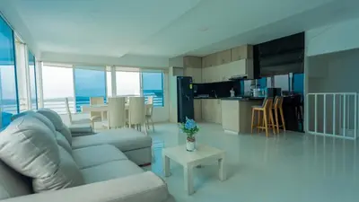 a living room and kitchen with a couch and a table at Hermoso Pent-House Piso 21 con vista privilegiada in Cartagena de Indias