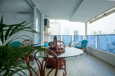 a room with a table and chairs on a balcony at Hermoso Pent-House Piso 21 con vista privilegiada in Cartagena de Indias