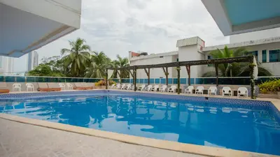 a swimming pool with chairs and a building at Hermoso Pent-House Piso 21 con vista privilegiada in Cartagena de Indias