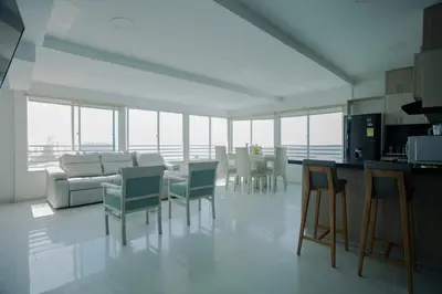 a kitchen and living room with chairs and a table at Hermoso Pent-House Piso 21 con vista privilegiada in Cartagena de Indias