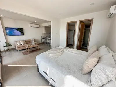a bedroom with a large bed and a living room at Apartamento Morros C28 acceso directo al Mar Manzanillo in Cartagena de Indias