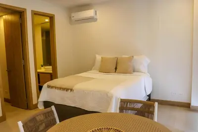 a bedroom with a bed and two tables and chairs at Apartamento Morros C28 acceso directo al Mar Manzanillo in Cartagena de Indias