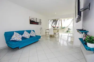 a living room with a blue couch and a table at Frontbeach Apartment Cartagena HighSpeed internet in Cartagena de Indias