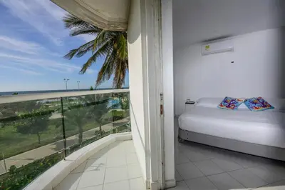 a bedroom with a bed and a view of the ocean at Frontbeach Apartment Cartagena HighSpeed internet in Cartagena de Indias
