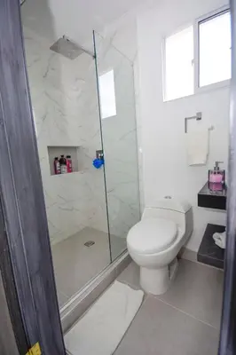 a white bathroom with a toilet and a shower at Frontbeach Apartment Cartagena HighSpeed internet in Cartagena de Indias