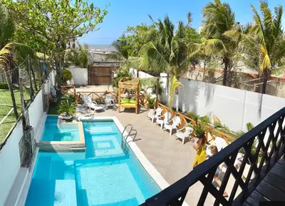 a woman standing next to a swimming pool on a balcony at Paradise BH in Maizal