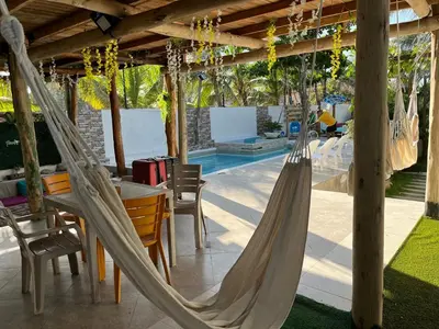 a patio with a table and chairs and hammocks at Paradise BH in Maizal