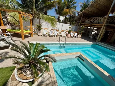 a swimming pool with a palm tree next to a house at Paradise BH in Maizal