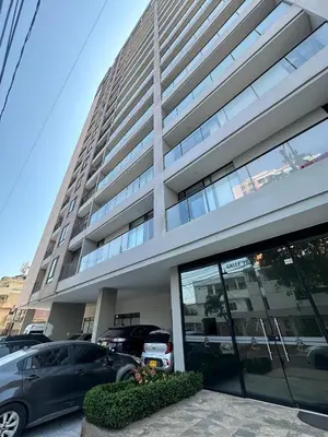 a large building with cars parked in front of it at ApartaEstudio in Barranquilla