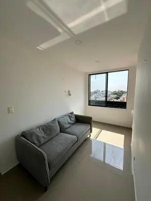 a living room with a couch and a large window at ApartaEstudio in Barranquilla