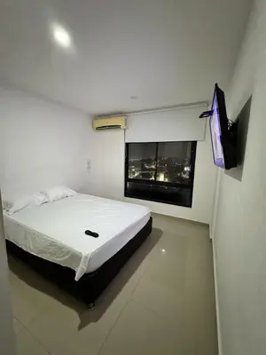 a bedroom with a bed and a flat screen tv at ApartaEstudio in Barranquilla