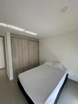 a bedroom with a large bed in a white room at ApartaEstudio in Barranquilla