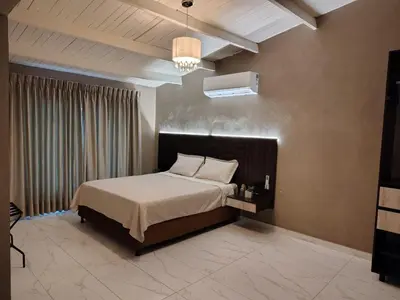 a bedroom with a bed and a chandelier at Laureles del Parque Loft in Barranquilla