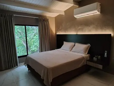 a bedroom with a large bed and a window at Laureles del Parque Loft in Barranquilla