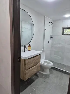 a bathroom with a sink and a toilet and a mirror at Laureles del Parque Loft in Barranquilla